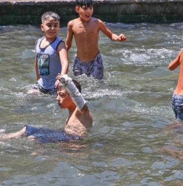 Sıcaktan bunalınca kolundaki alçıya rağmen süs havuzuna girdi