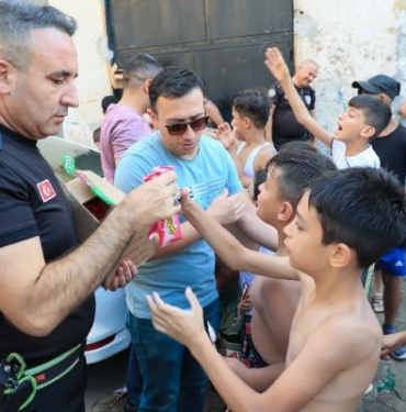 Sıcaktan bunalıp süs havuzunda serinleyen çocuklara polisten dondurma sürprizi
