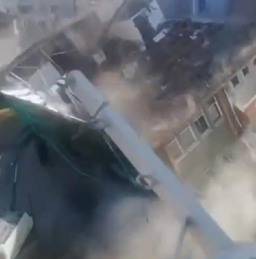 Malatya'da ağır hasarlı binanın kepçenin üstüne çökmesi kamerada