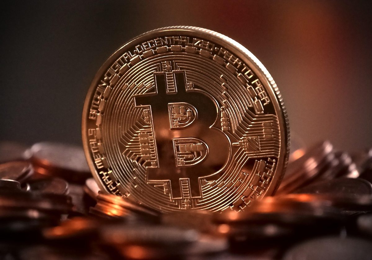 Altın renkli fiziksel Bitcoin jetonu; kripto paralar ve dijital varlık yakın çekimi.