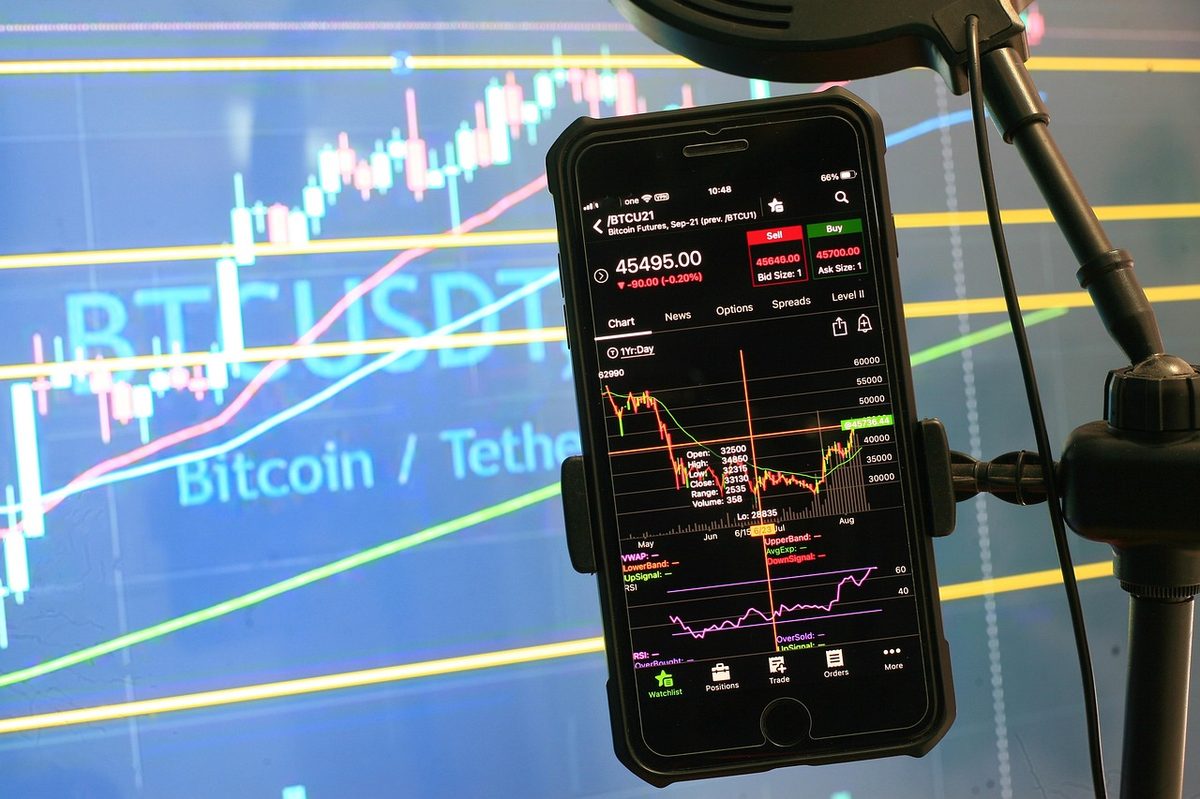 Tripoddaki telefonda grafik ekranı; bitcoin videoları ve analiz çekimi kurulum görseli.
