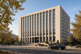 Ankara’da sonbahar öğleden sonrasında geniş bir caddenin karşısından görülen, merkez bankası genel merkezine benzeyen modern taş ve cam bina, Merkez Bankası’nın faiz indirimi için temsili görsel